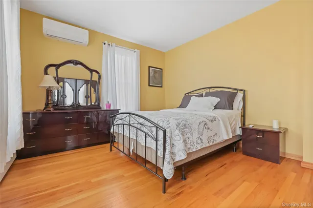 a bedroom with a bed and a dresser with mirror