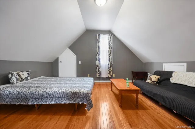 a bedroom with bed and wooden floor