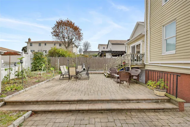 a view of a patio with table and chairs with wooden floor and fence