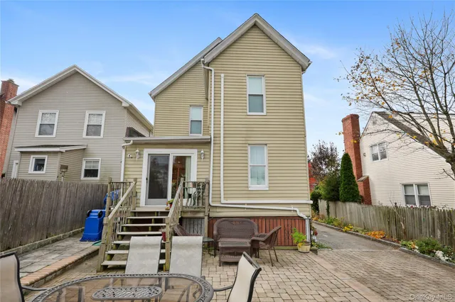 a view of a house with wooden deck and furniture