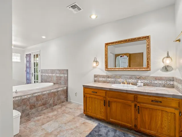 a bathroom with a tub sink and mirror