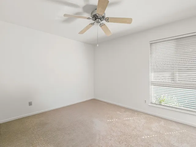 a bedroom with a bed and a chandelier fan