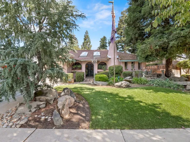 a front view of a house with yard and green space