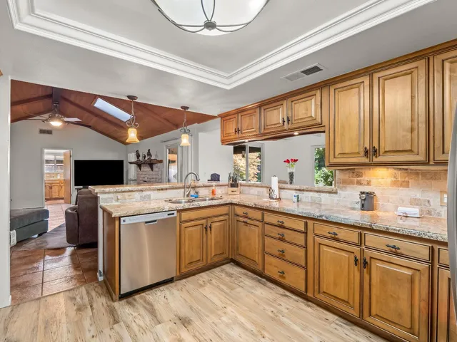 a kitchen with stainless steel appliances granite countertop a refrigerator sink and cabinets