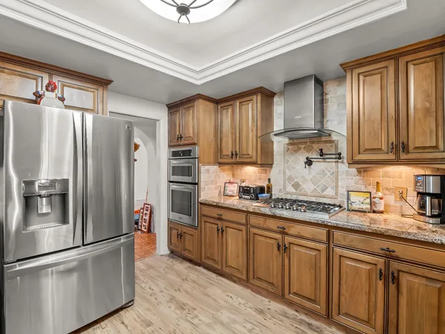 a kitchen with wooden cabinets a refrigerator and a sink