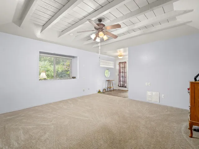 en empty room with windows and ceiling fan