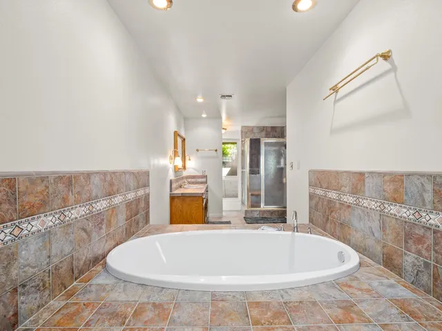 a bathroom with a granite countertop sink a mirror and a shower