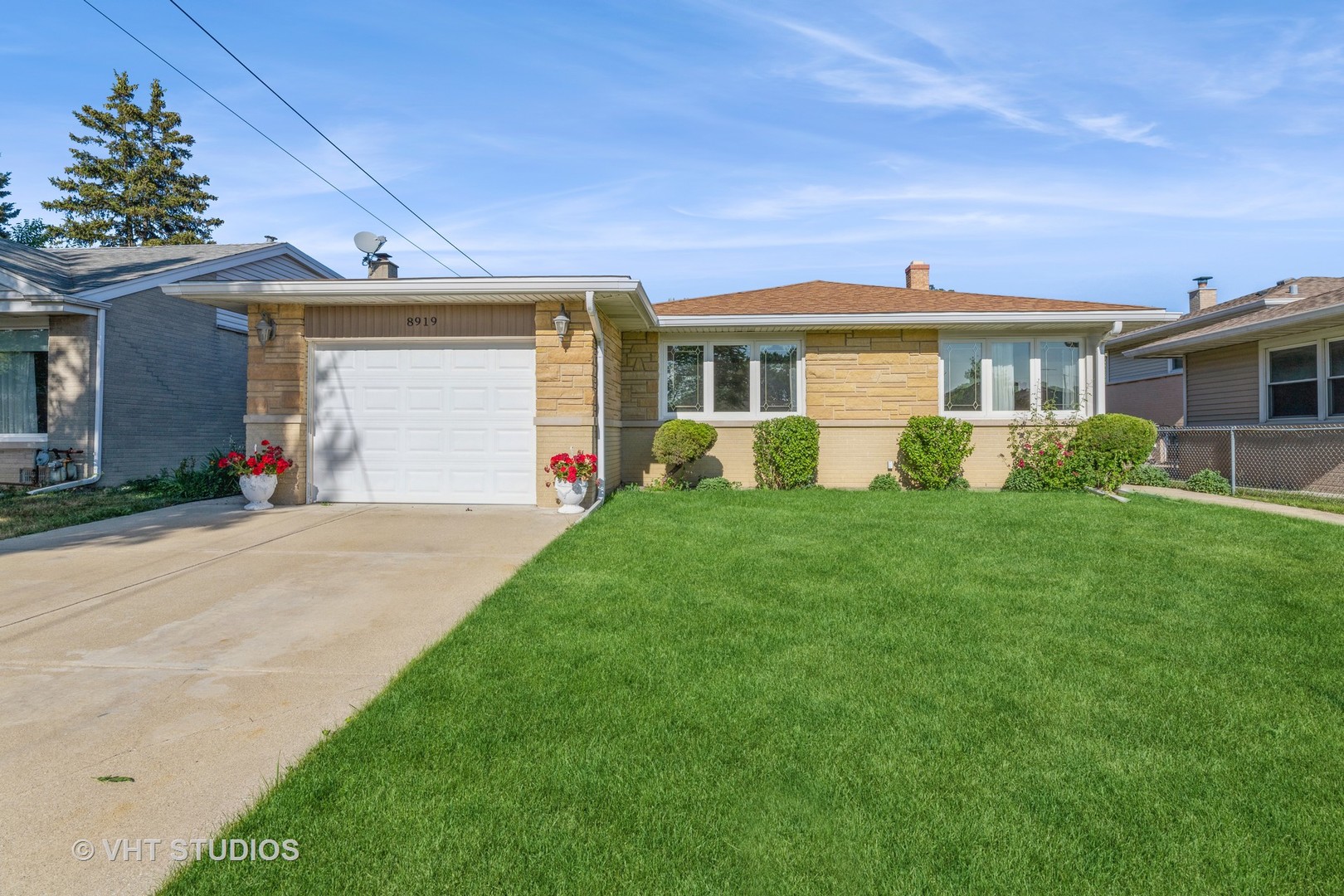 a front view of a house with a yard and potted plants