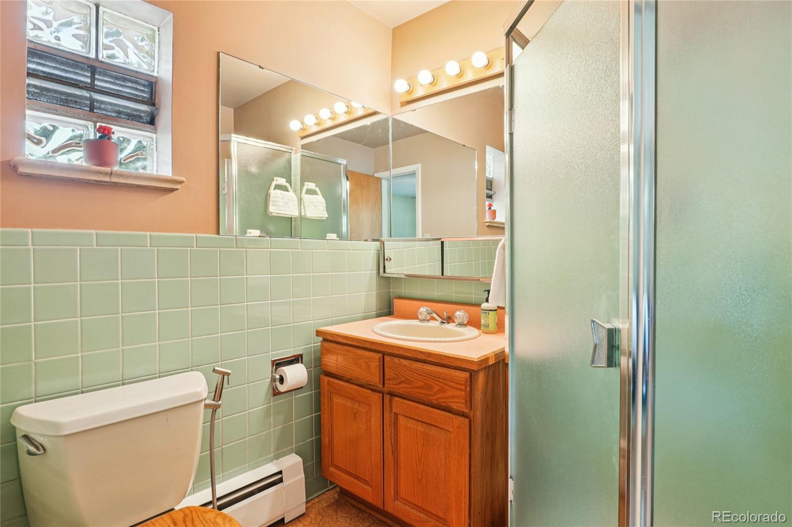 6920 West 47th Place Wheat Ridge, CO 80033 - Photo 17 of 43 a bathroom with a sink a toilet and shower