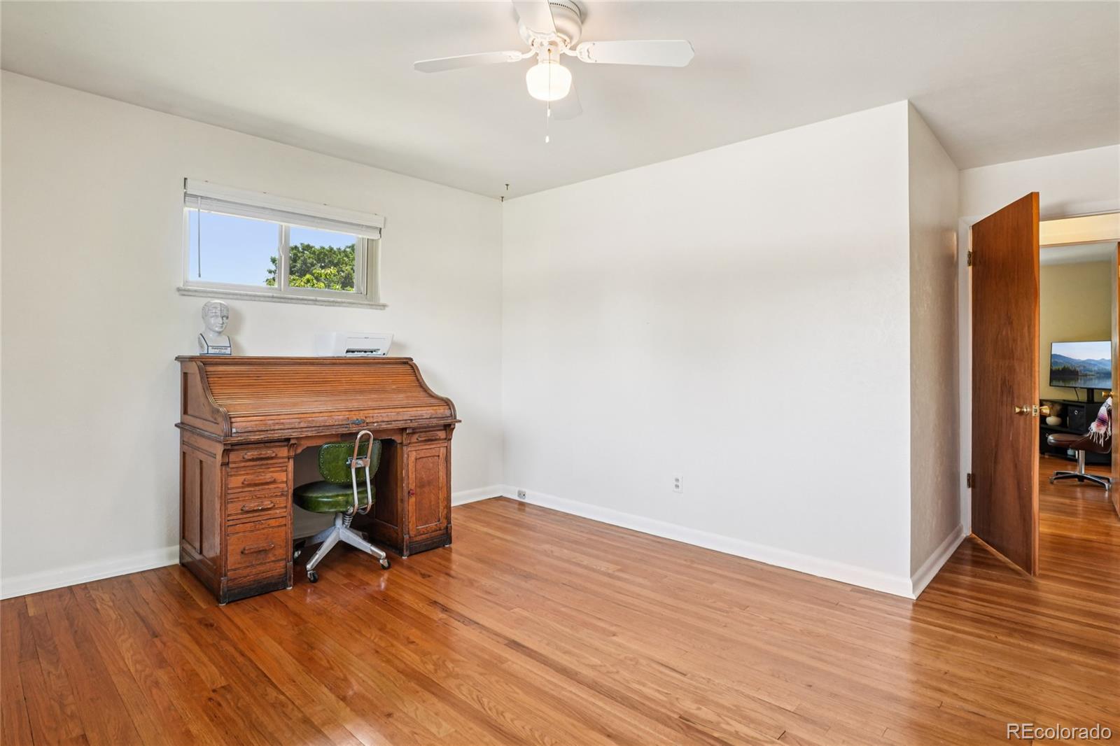 6920 West 47th Place Wheat Ridge, CO 80033 - Photo 22 of 43 a room with wooden floor and furniture