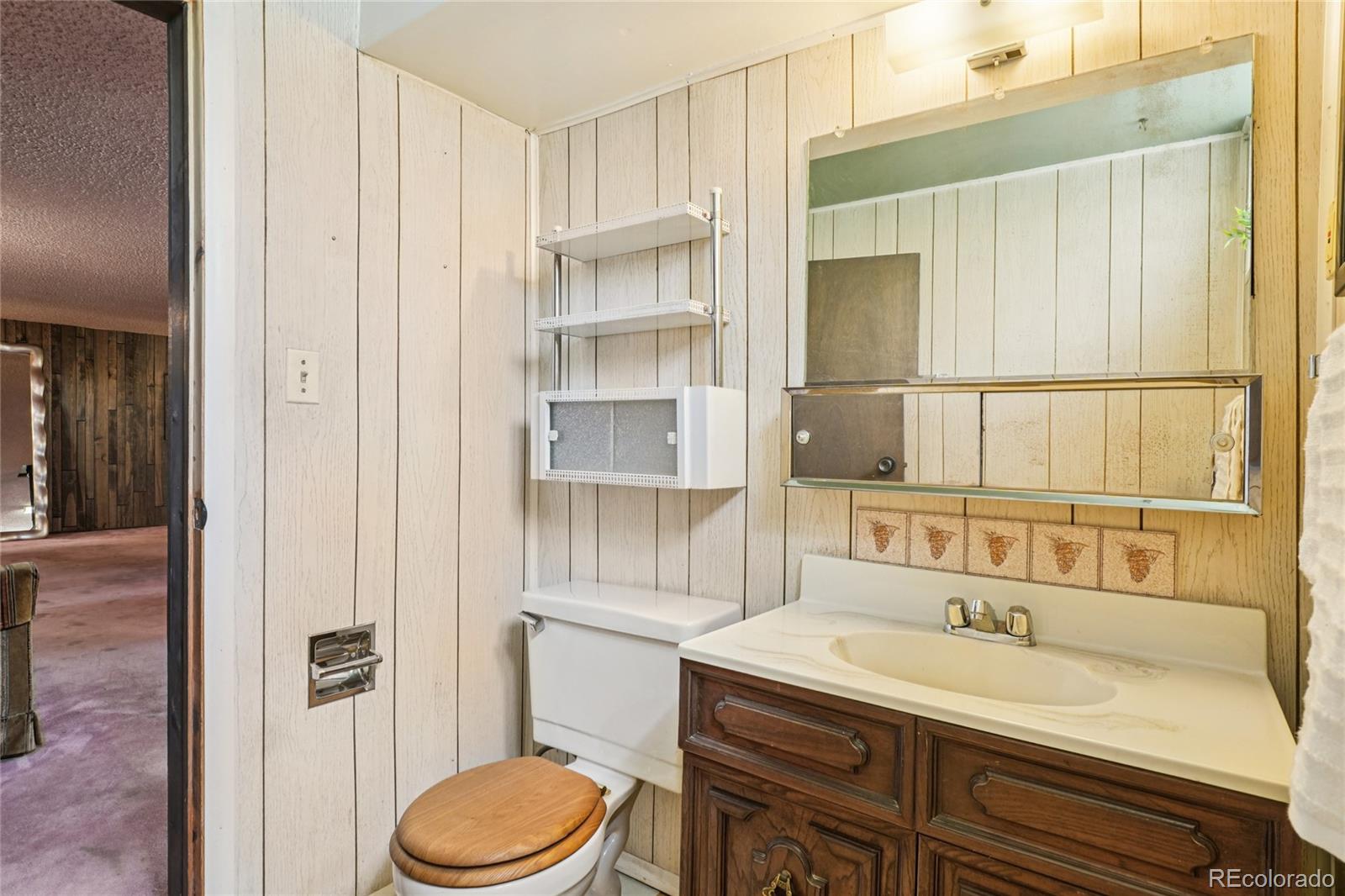 6920 West 47th Place Wheat Ridge, CO 80033 - Photo 32 of 43 a bathroom with a sink toilet vanity and shower