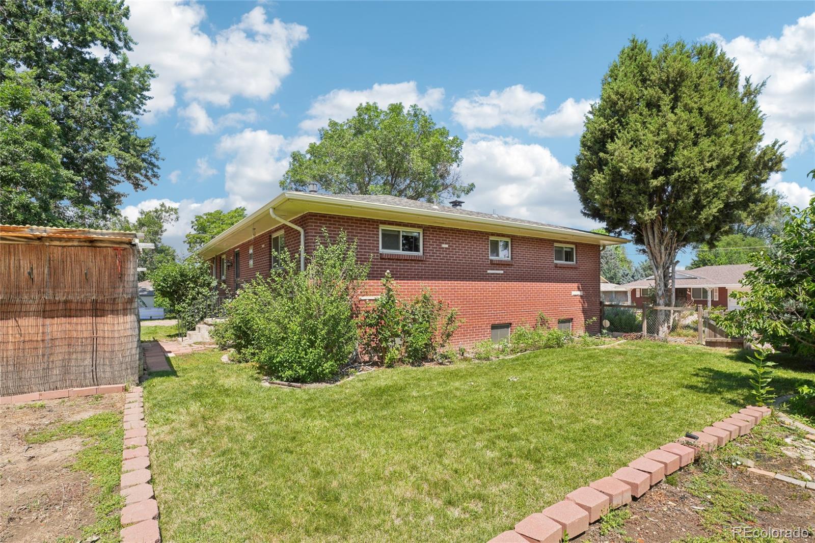 6920 West 47th Place Wheat Ridge, CO 80033 - Photo 37 of 43 a front view of a house with garden