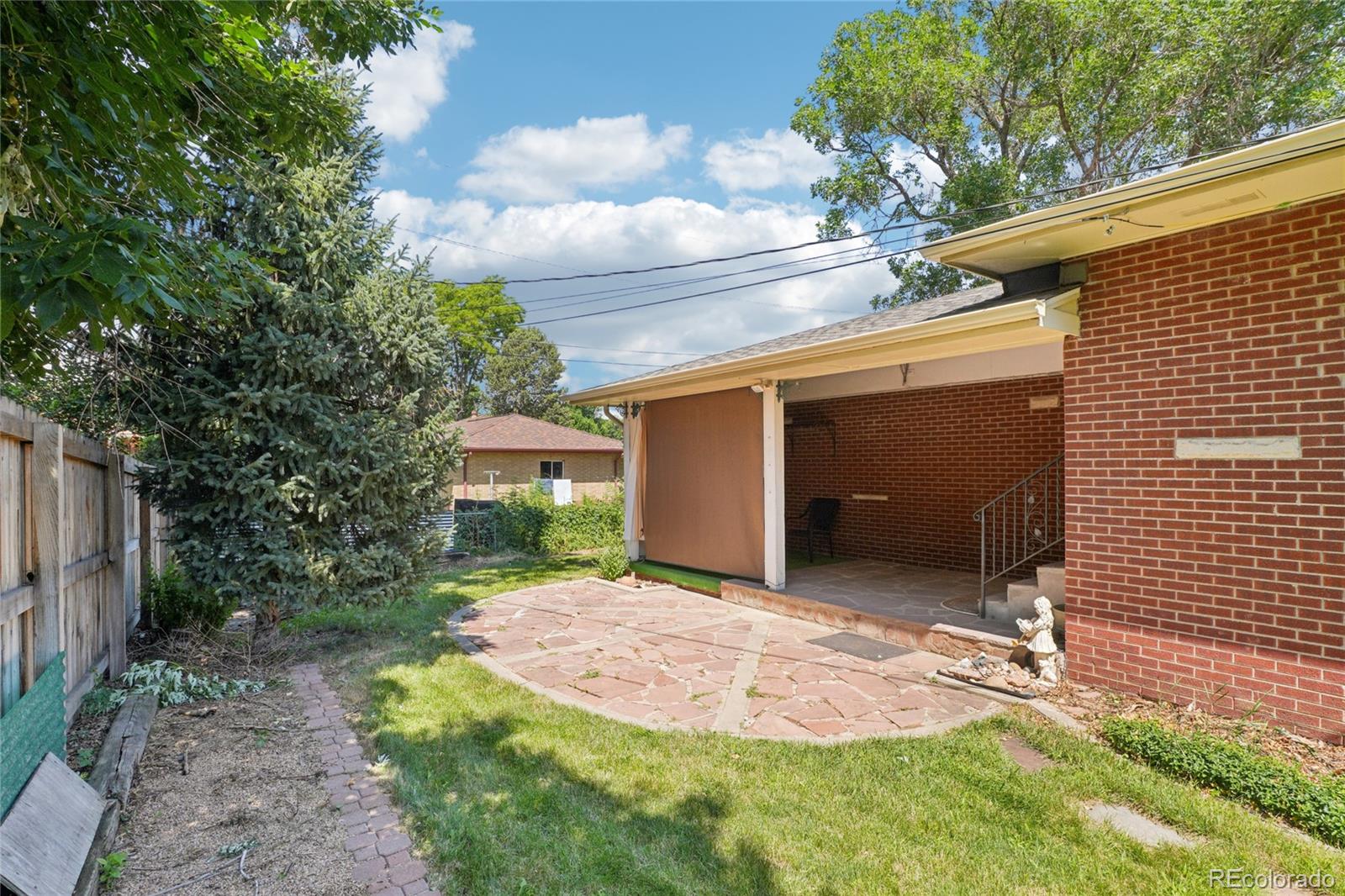 6920 West 47th Place Wheat Ridge, CO 80033 - Photo 39 of 43 a backyard of a house with table and chairs