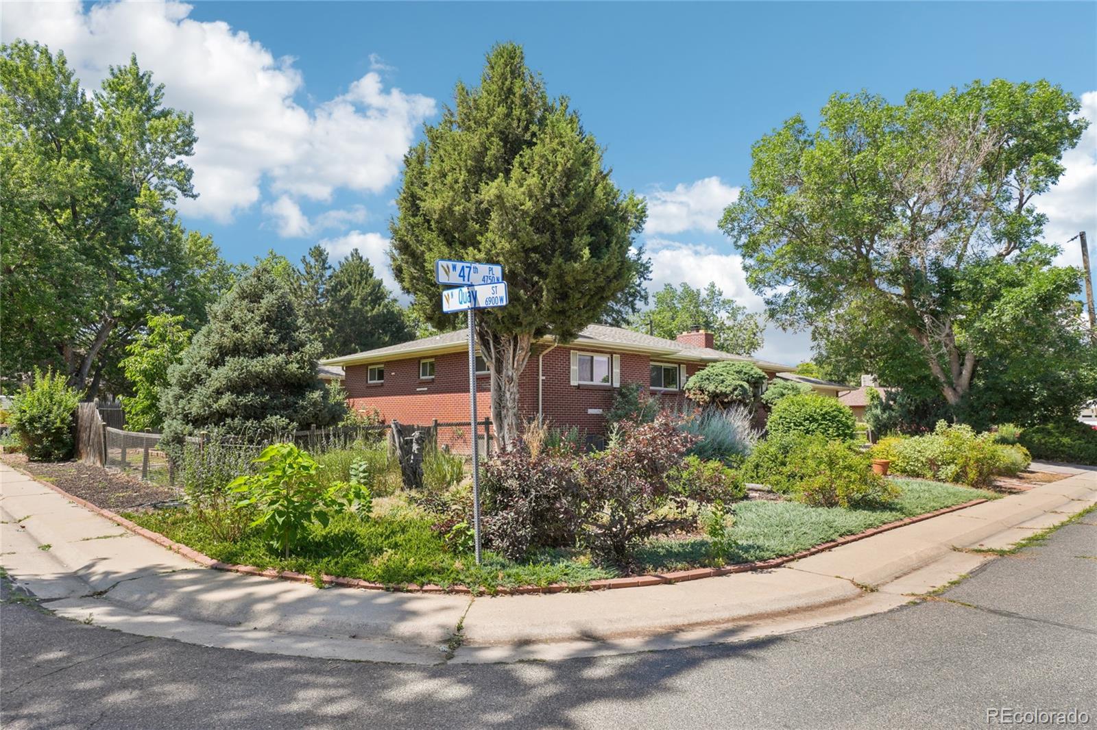6920 West 47th Place Wheat Ridge, CO 80033 - Photo 42 of 43 a front view of a house with a yard and fountain in middle