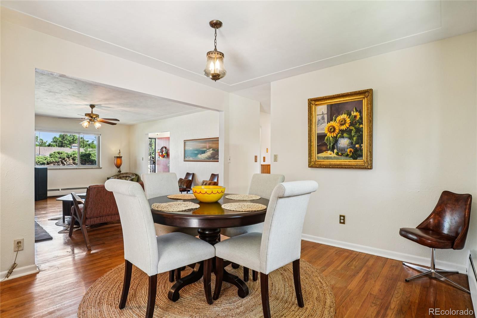 6920 West 47th Place Wheat Ridge, CO 80033 - Photo 9 of 43 a view of a dining room with furniture and wooden floor