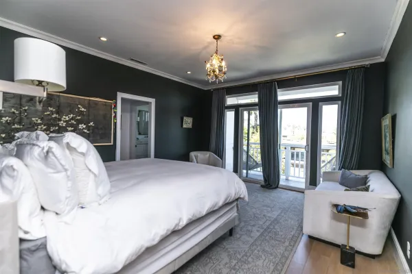 a spacious bedroom with a large bed and a chandelier