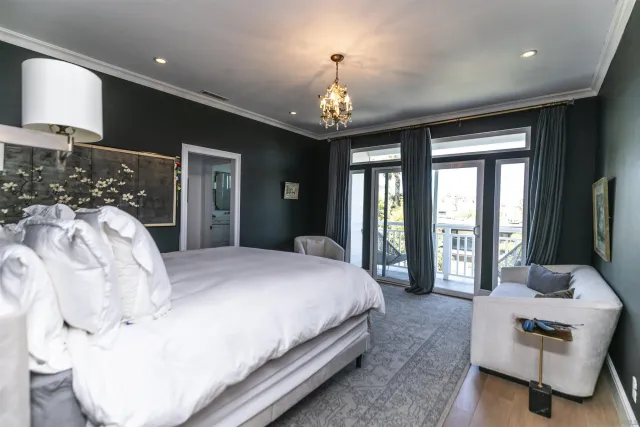 a spacious bedroom with a large bed and a chandelier