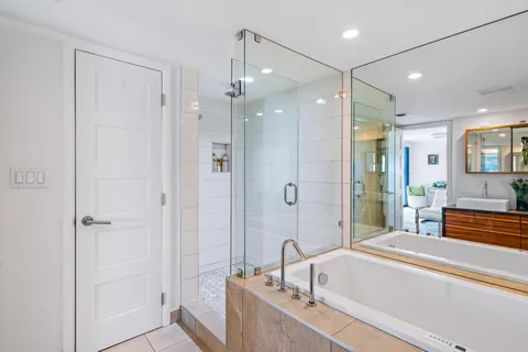 a living room with furniture a large window and a chandelier