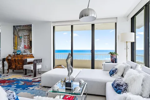 a living room with furniture large window and wooden floor