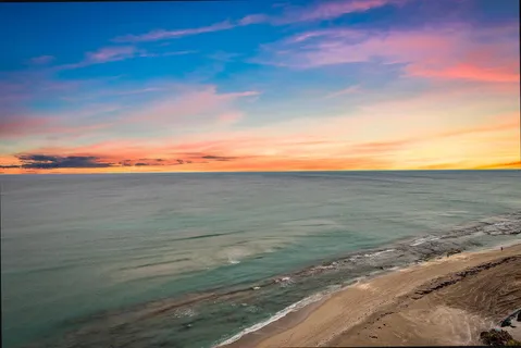 a dining room with stainless steel appliances kitchen island granite countertop a refrigerator a stove a dining table and chairs