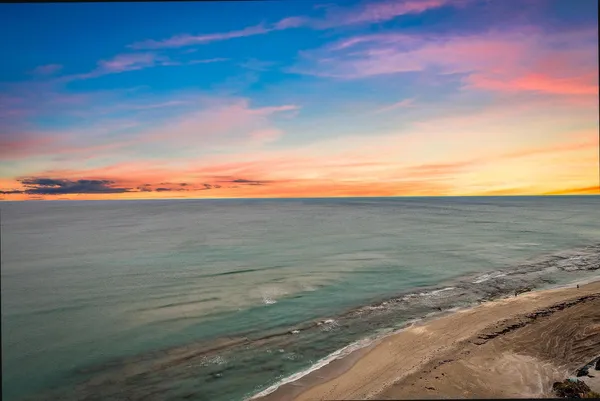 a dining room with stainless steel appliances kitchen island granite countertop a refrigerator a stove a dining table and chairs