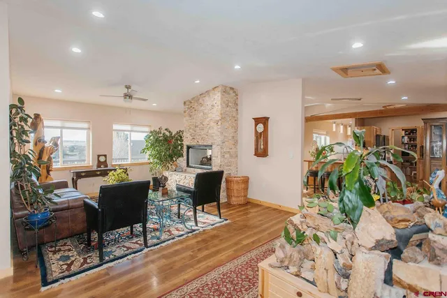 a living room with furniture a wooden floor and a potted plant