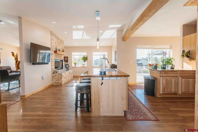 a kitchen with stainless steel appliances kitchen island granite countertop a stove a sink a dining table and chairs