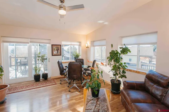 a living room with furniture potted plant and a large window