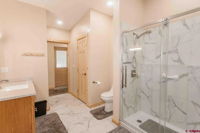 a bathroom with a sink a toilet and shower