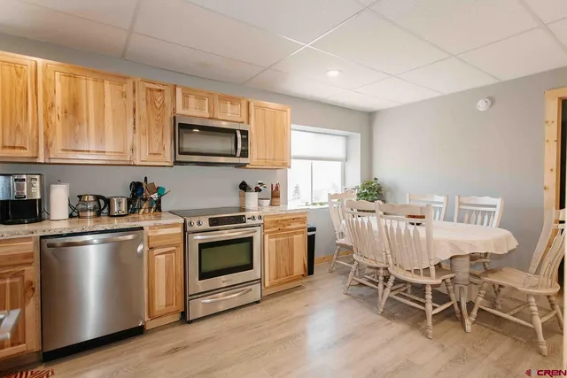 a kitchen with stainless steel appliances granite countertop a stove a sink dishwasher a microwave oven with cabinets and wooden floor