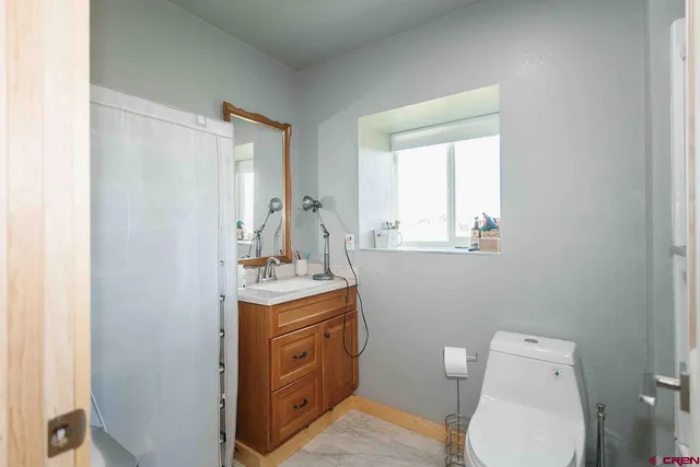 a bathroom with a toilet a sink and mirror
