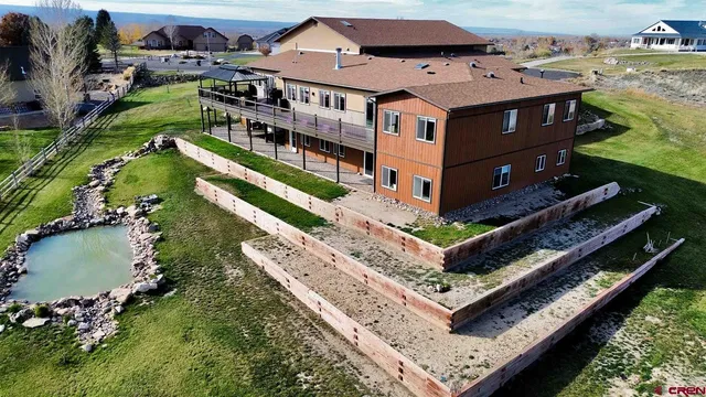 an aerial view of a house with a garden and lake view