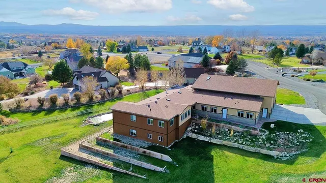 an aerial view of a house with a garden and lake view