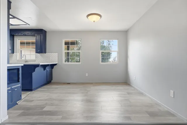 a view of an empty room with window and cabinet