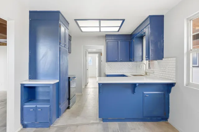 a kitchen with kitchen island granite countertop a sink cabinets and stainless steel appliances
