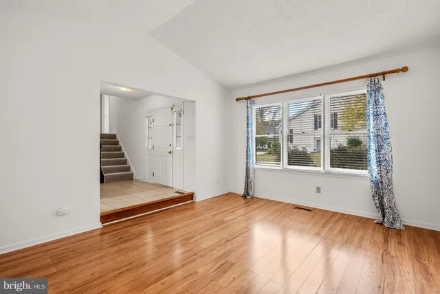 a view of a dining room with furniture a chandelier and wooden floor
