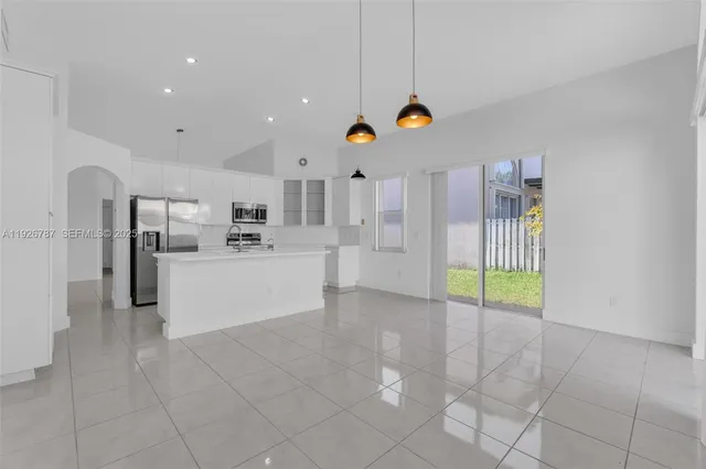 a kitchen with stainless steel appliances granite countertop a stove microwave and refrigerator