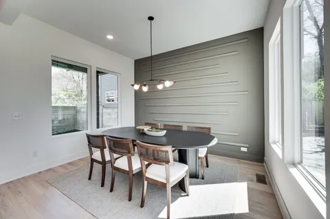 a dining room with furniture a chandelier and wooden floor