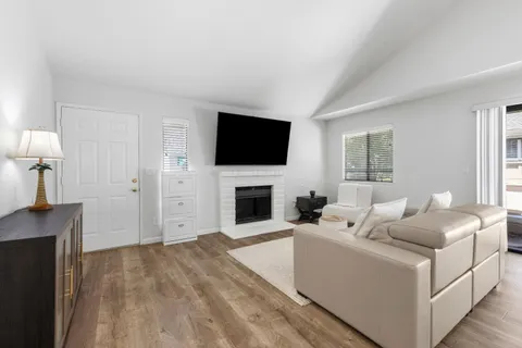 a living room with furniture a fireplace and a flat screen tv