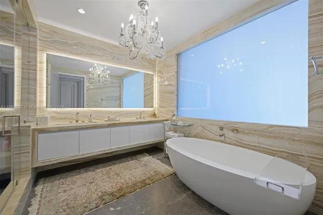 a bedroom with a large bed and a chandelier