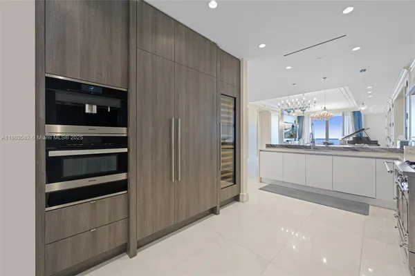 a kitchen with stainless steel appliances kitchen island granite countertop a refrigerator and a stove top oven