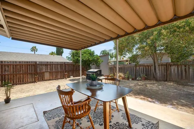 a patio with glass top table and chairs