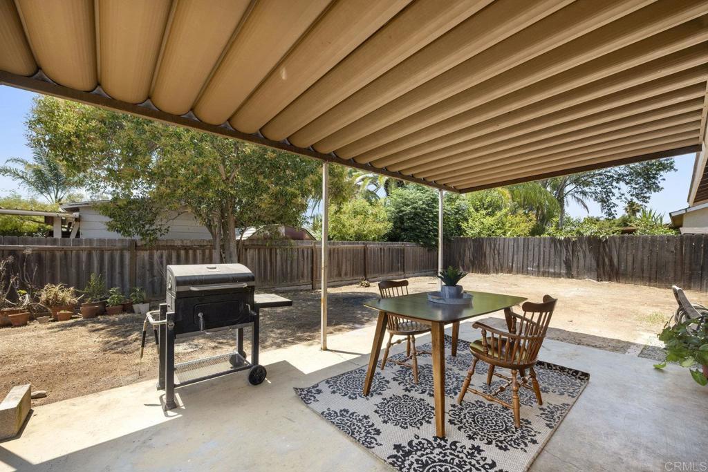 809 Buchanan Street Escondido, CA 92027 - Photo 25 of 32 a view of a patio with table and chairs and couches with wooden fence and plants