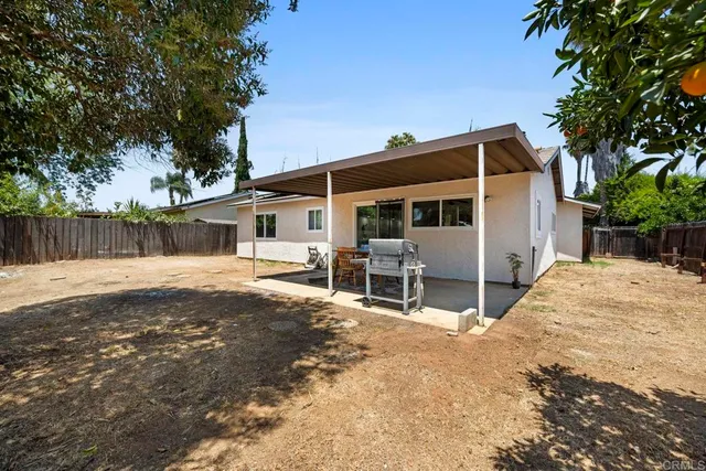 a view of a house with backyard and a tree