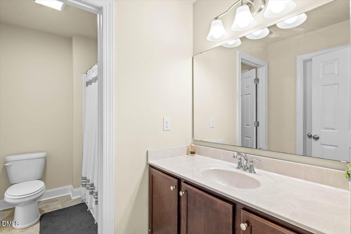 704 Haw River Hopedale Road Burlington, NC 27217 - Photo 35 of 49 a bathroom with a sink a toilet and a mirror