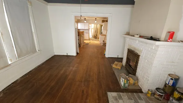 a view of a livingroom with wooden floor and a fireplace