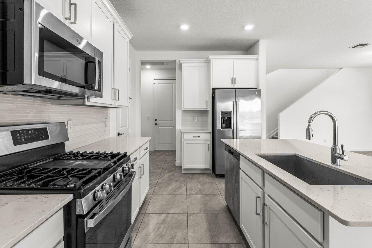 19659 Rugged Trunk Trail Loxahatchee, FL 33470 - Photo 13 of 61 a kitchen with stainless steel appliances granite countertop a sink and a stove