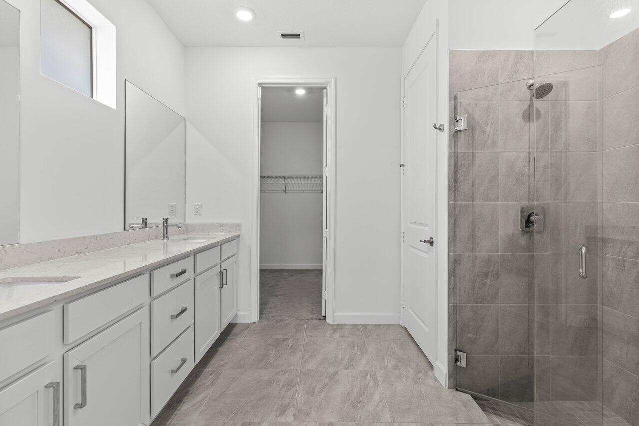 19659 Rugged Trunk Trail Loxahatchee, FL 33470 - Photo 16 of 61 a spacious bathroom with a granite countertop sink a mirror and a shower