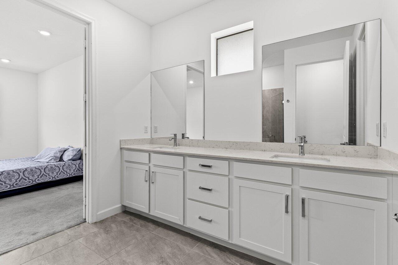 19659 Rugged Trunk Trail Loxahatchee, FL 33470 - Photo 17 of 61 a bathroom with a double vanity sink and a mirror