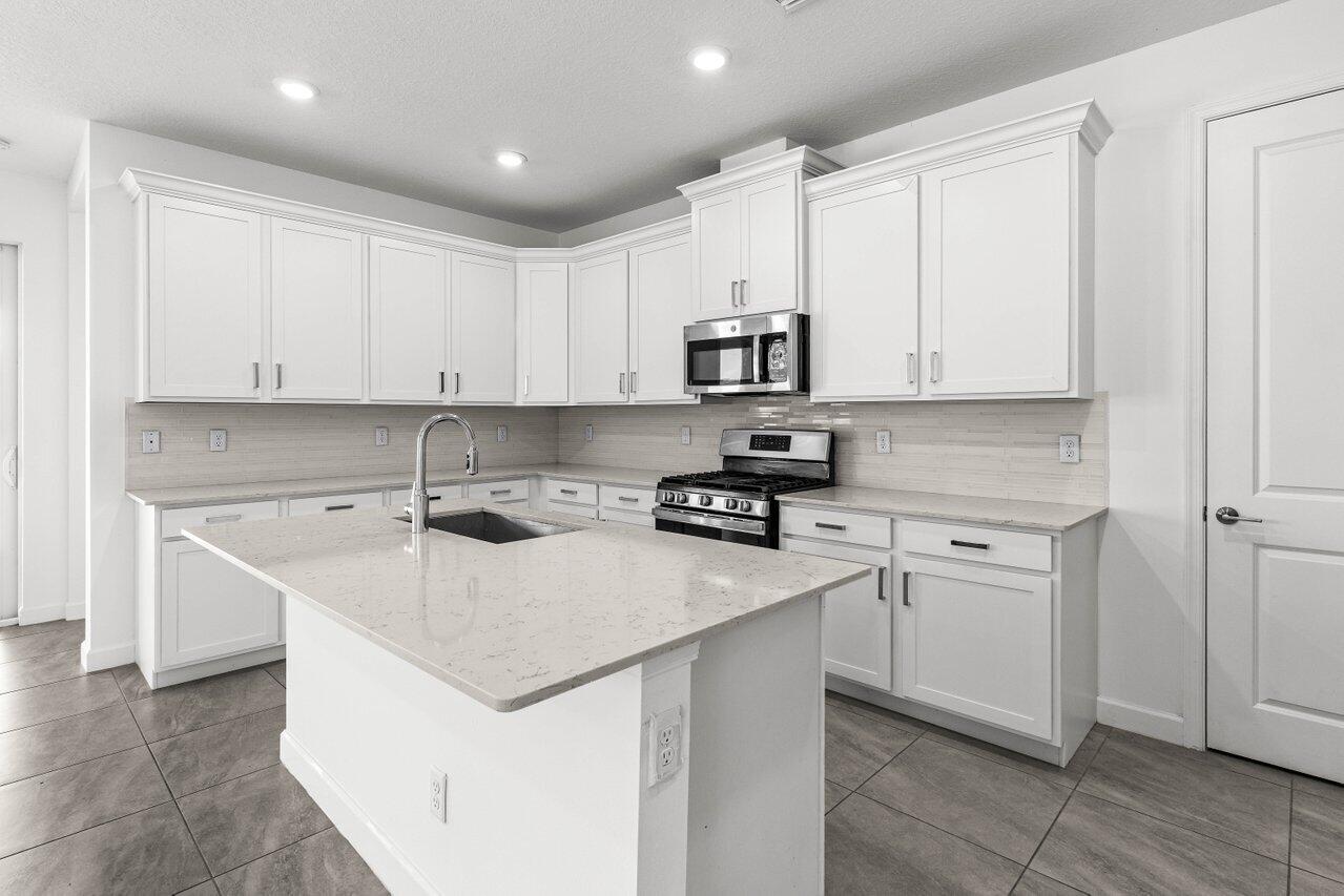 19659 Rugged Trunk Trail Loxahatchee, FL 33470 - Photo 2 of 61 a kitchen with stainless steel appliances white cabinets and a sink